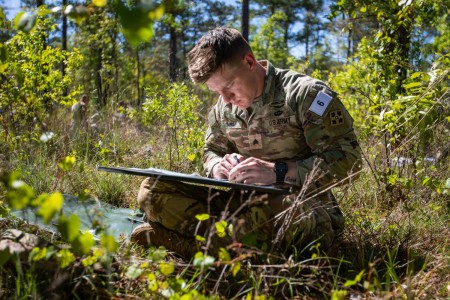 Sgt. Austin High from 2nd Squadron, 1st Cavalry Regiment, 1st Stryker Brigade Combat Team, 4th Infantry Division, uses a map and protractor to determine the distance between two plotted points during the 2023 Best Mortar Competition, Fort Benning, Georgia, April 10, 2023. Mortarmen use analog tools to first detrmine the distance between two points and then determine the elevation necessary to shoot mortar rounds that distance. 