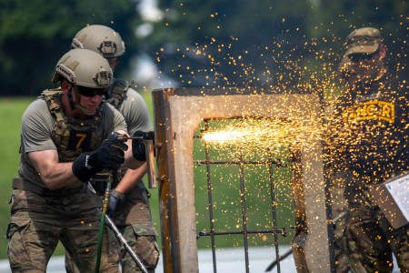 Capt. Aaron Dominic, a Soldier assigned to the 2nd Battalion, 23rd Infantry Regiment, 1st Stryker Brigade Combat Team, 4th Infantry Division cuts through an obstacle designed to simulate a steel-reinforced window during the Best Ranger Competition at Columbus, Georgia, on April 15, 2023. The Best Ranger Competition is held annually at Fort Benning, Georgia, where for over 60 hours, ranger-qualified soldiers compete in a series of challenges ranging from physical fitness, technical capabilities, and marksmanship.